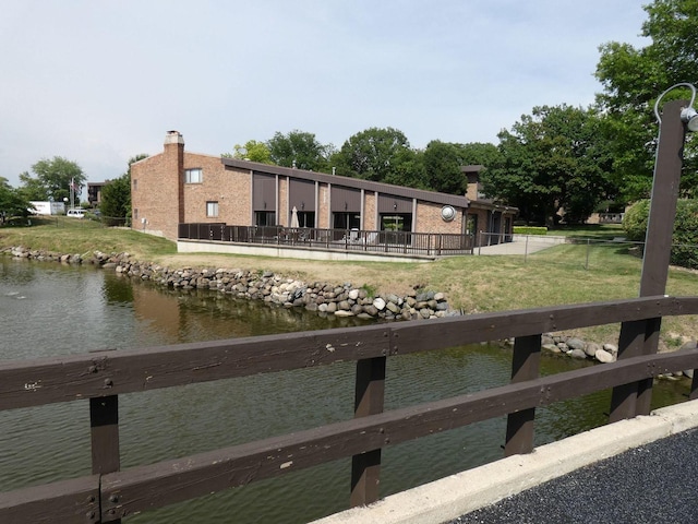 exterior space with a water view and a lawn