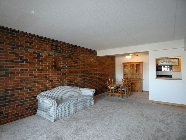 unfurnished living room featuring brick wall, carpet floors, and a textured ceiling