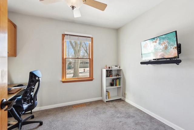 carpeted office space featuring ceiling fan