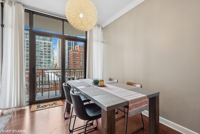 dining area featuring hardwood / wood-style floors, crown molding, and expansive windows