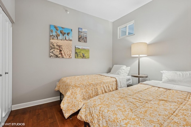 bedroom with dark wood-type flooring and a closet