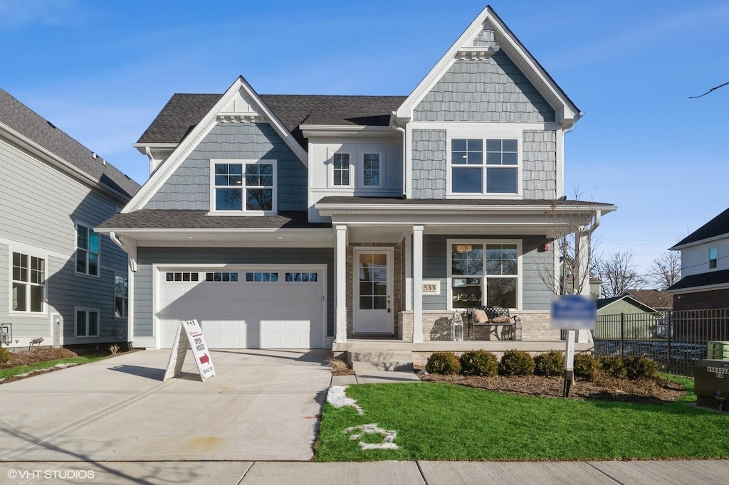 view of front of house with a garage, a front yard, and a porch