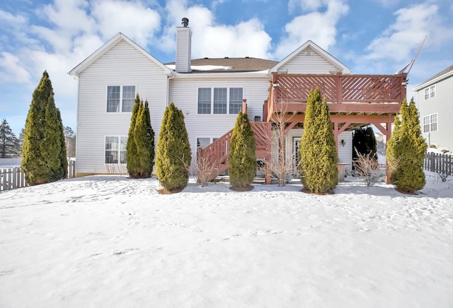 snow covered property featuring stairs, a chimney, and a wooden deck