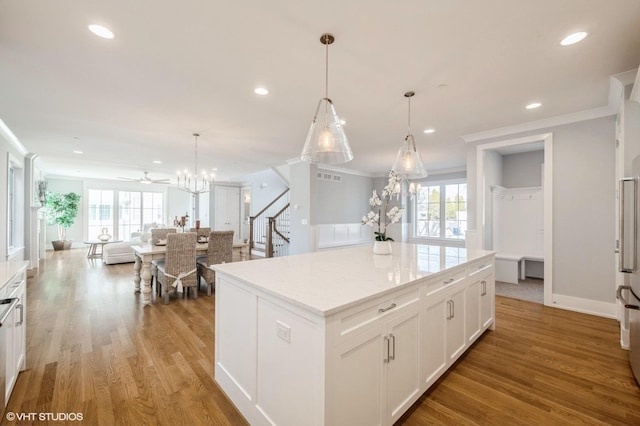 kitchen featuring a center island, a wealth of natural light, hanging light fixtures, white cabinets, and light wood-type flooring