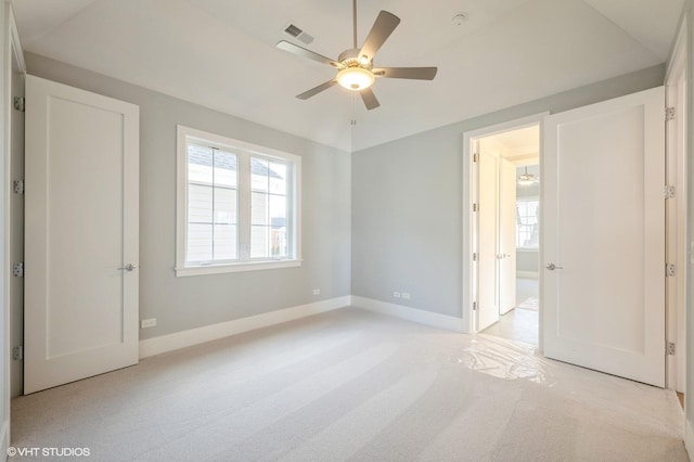 unfurnished bedroom featuring ceiling fan, vaulted ceiling, and light carpet