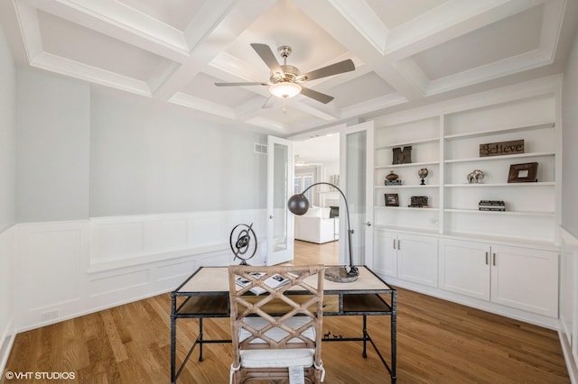 interior space featuring beamed ceiling, light hardwood / wood-style floors, coffered ceiling, built in features, and ceiling fan