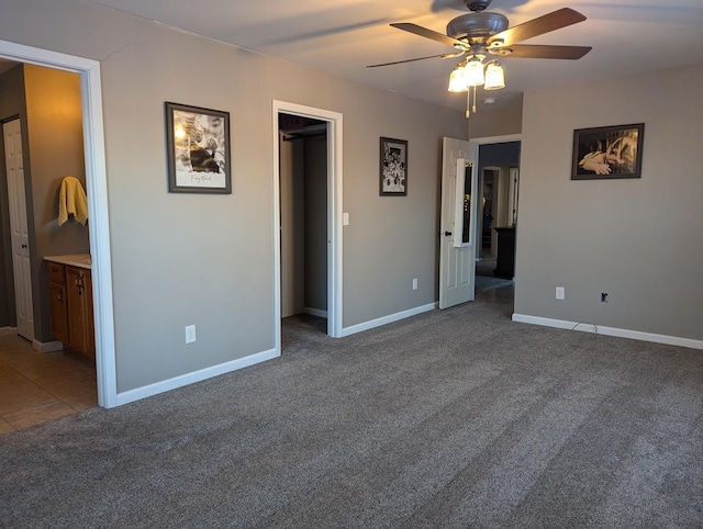 unfurnished bedroom with ceiling fan, connected bathroom, and carpet floors