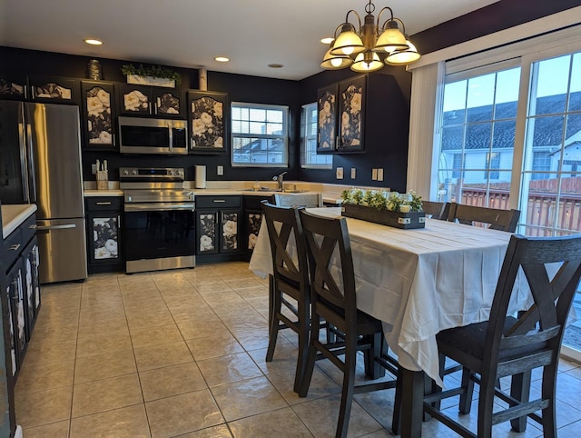 dining space with a mountain view, a chandelier, sink, and light tile patterned flooring