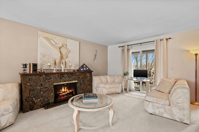 carpeted living room featuring a stone fireplace