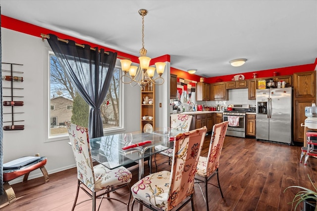 dining room with dark hardwood / wood-style flooring, sink, and a notable chandelier