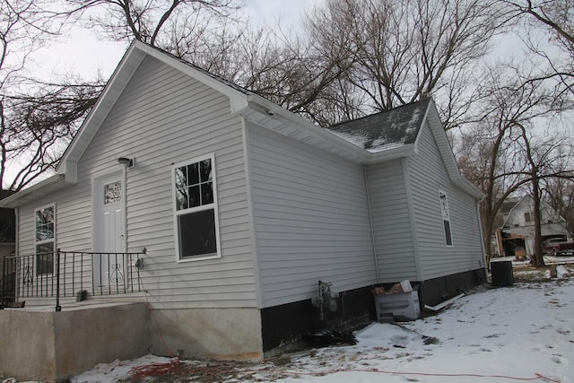 snow covered property with central AC unit