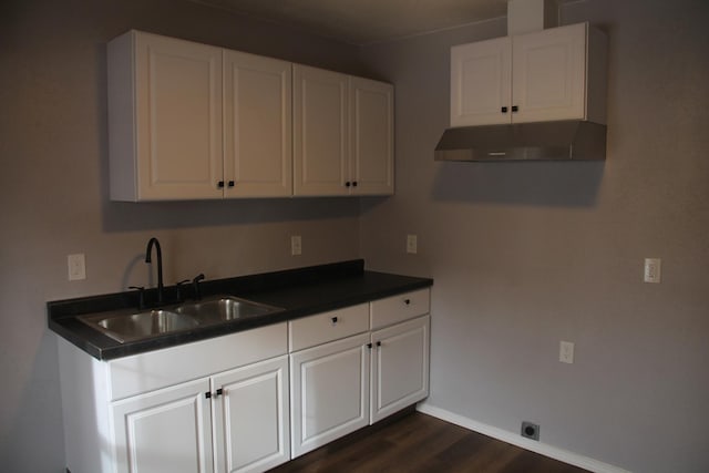 kitchen featuring dark hardwood / wood-style flooring, sink, and white cabinets