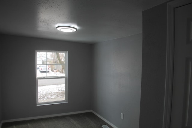 carpeted spare room with a textured ceiling