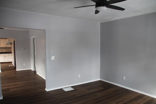 empty room featuring ceiling fan and dark hardwood / wood-style floors