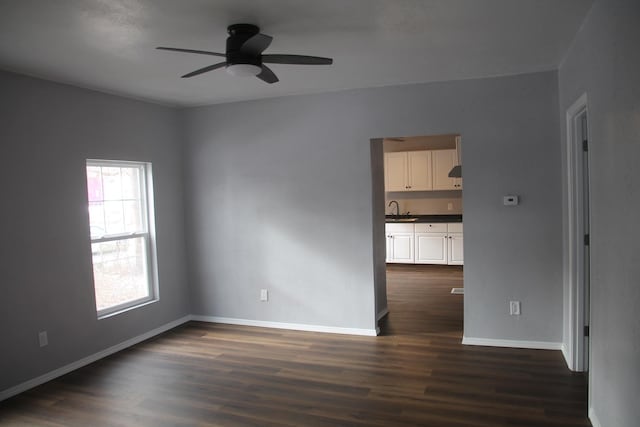 empty room with ceiling fan, sink, and dark hardwood / wood-style floors