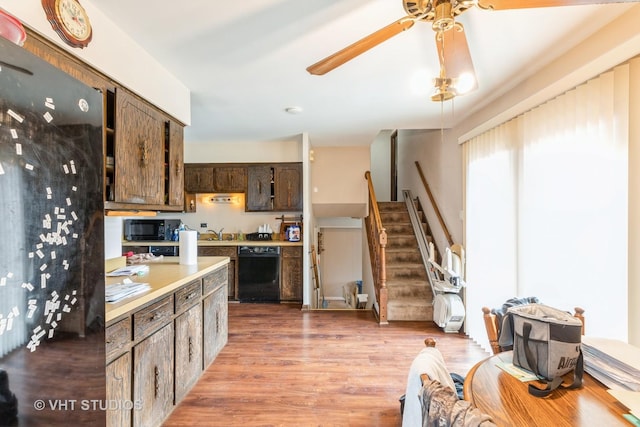 kitchen featuring ceiling fan, light countertops, dark brown cabinets, light wood-type flooring, and black appliances