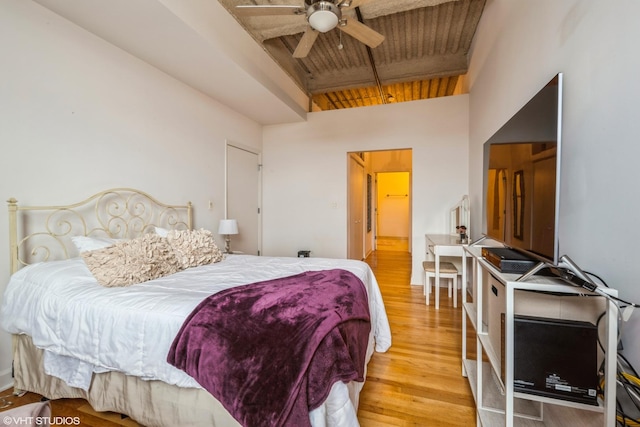 bedroom featuring light hardwood / wood-style flooring, ceiling fan, high vaulted ceiling, wooden ceiling, and beamed ceiling