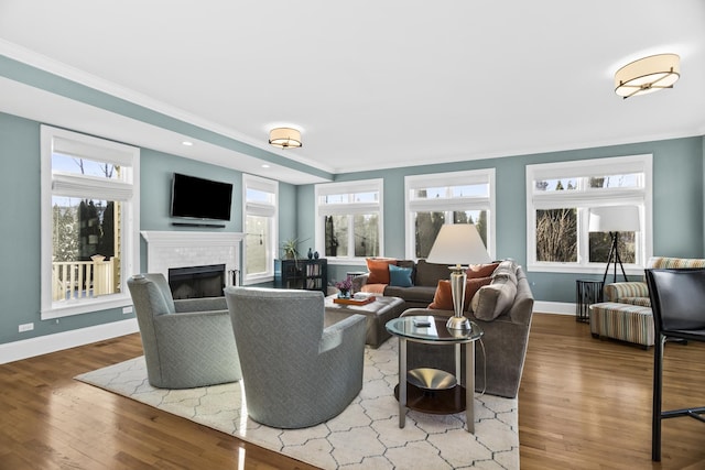 living room with ornamental molding, hardwood / wood-style floors, and a brick fireplace