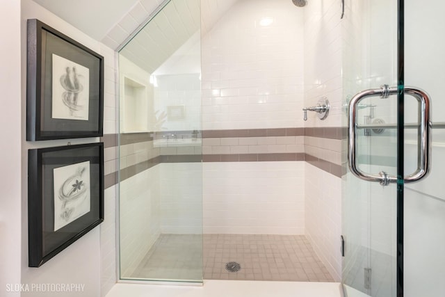 bathroom with a shower with door and vaulted ceiling