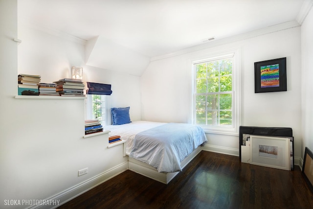 bedroom with crown molding and dark wood-type flooring