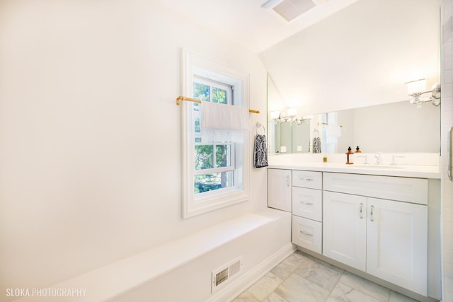 bathroom featuring vaulted ceiling, a notable chandelier, and vanity