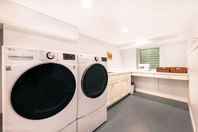 clothes washing area with cabinets and washing machine and dryer