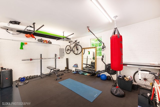 exercise area with brick wall and electric panel