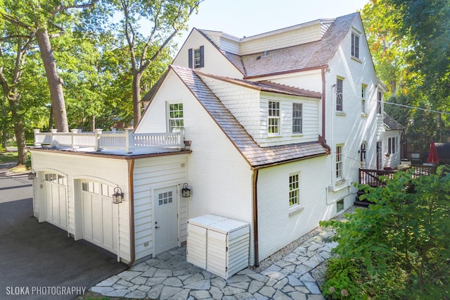 back of property with a balcony and a garage