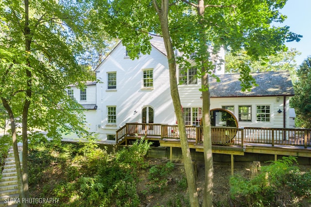 rear view of house featuring a wooden deck