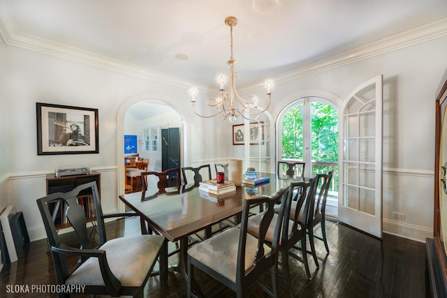 dining space featuring crown molding, dark hardwood / wood-style floors, and a chandelier