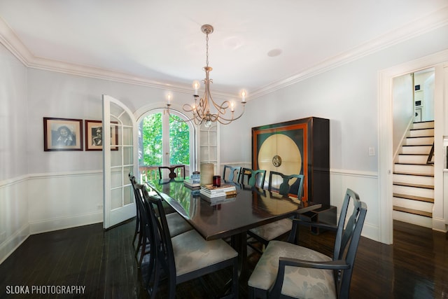 dining area with dark wood-type flooring, ornamental molding, an inviting chandelier, and french doors