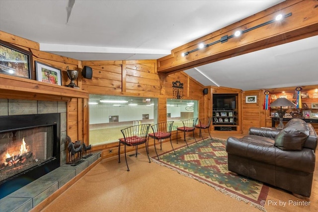 living room with a fireplace, wood walls, and lofted ceiling with beams