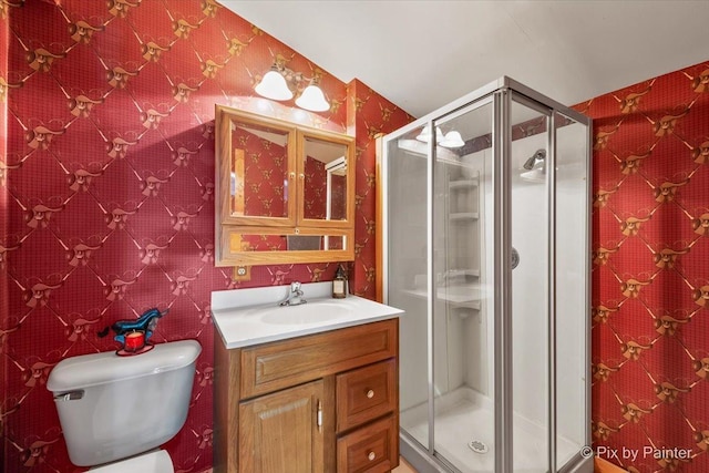 bathroom featuring vanity, toilet, and a shower with shower door