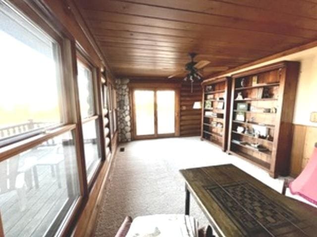 sunroom with ceiling fan and wood ceiling