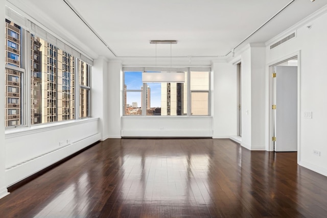 empty room with ornamental molding, dark hardwood / wood-style floors, and baseboard heating