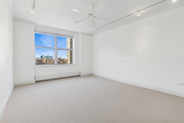 carpeted empty room featuring crown molding, track lighting, and ceiling fan