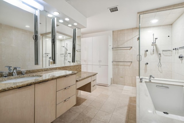 bathroom with tile walls, vanity, tile patterned floors, and plus walk in shower