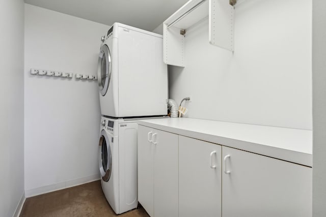 laundry room with cabinets and stacked washing maching and dryer