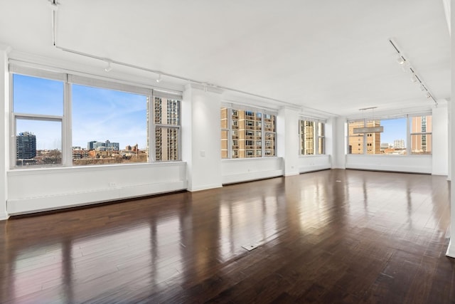 unfurnished living room featuring plenty of natural light and dark wood-type flooring