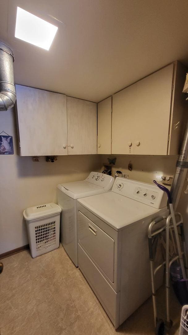 washroom with cabinets and washing machine and clothes dryer