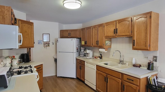 kitchen with light hardwood / wood-style floors, sink, white appliances, and backsplash