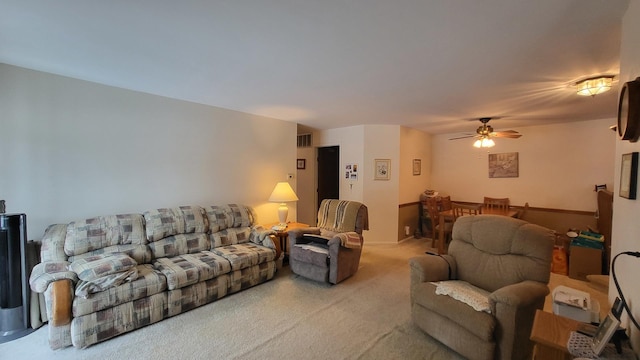 carpeted living room with ceiling fan