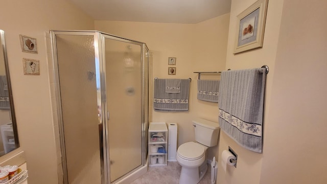 bathroom featuring toilet and a shower with door