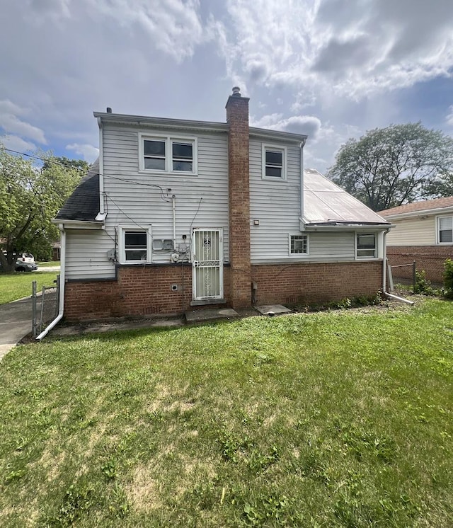 rear view of house featuring a lawn