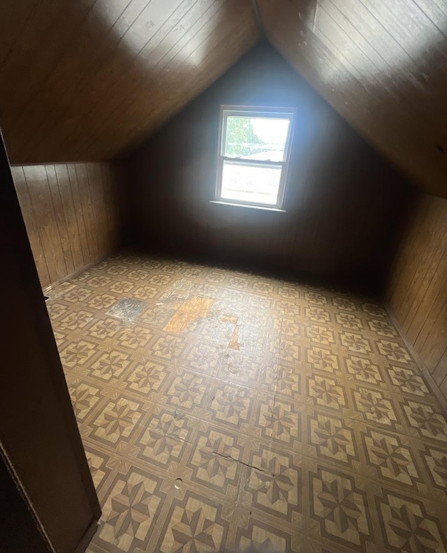 bonus room featuring wooden walls and vaulted ceiling