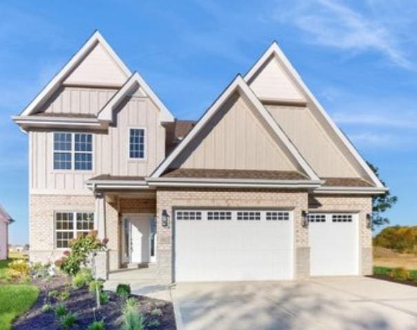 craftsman inspired home featuring brick siding, board and batten siding, an attached garage, and driveway