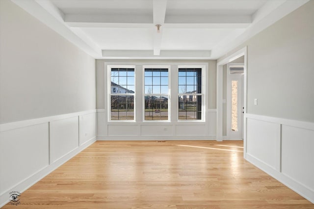 unfurnished room featuring light hardwood / wood-style floors, beamed ceiling, and coffered ceiling