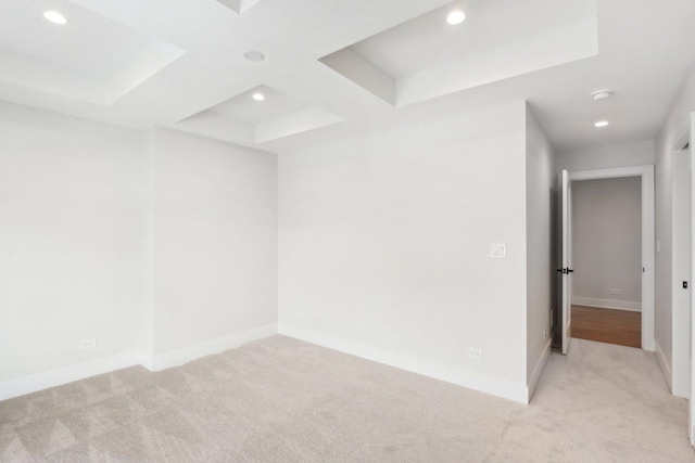 unfurnished room featuring coffered ceiling and light carpet