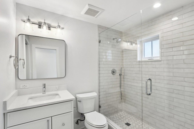 bathroom with vanity, toilet, and a shower with shower door