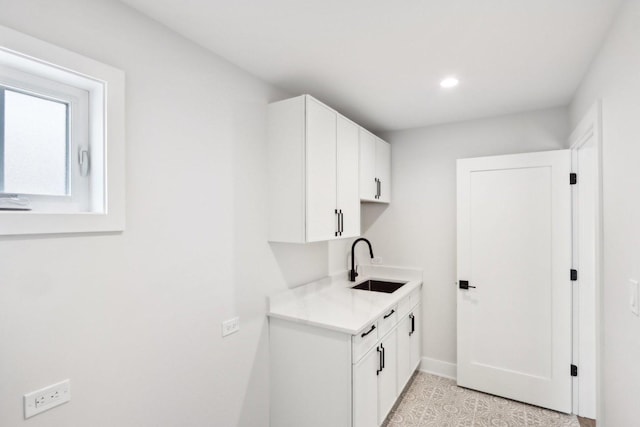 clothes washing area featuring sink and light tile patterned flooring